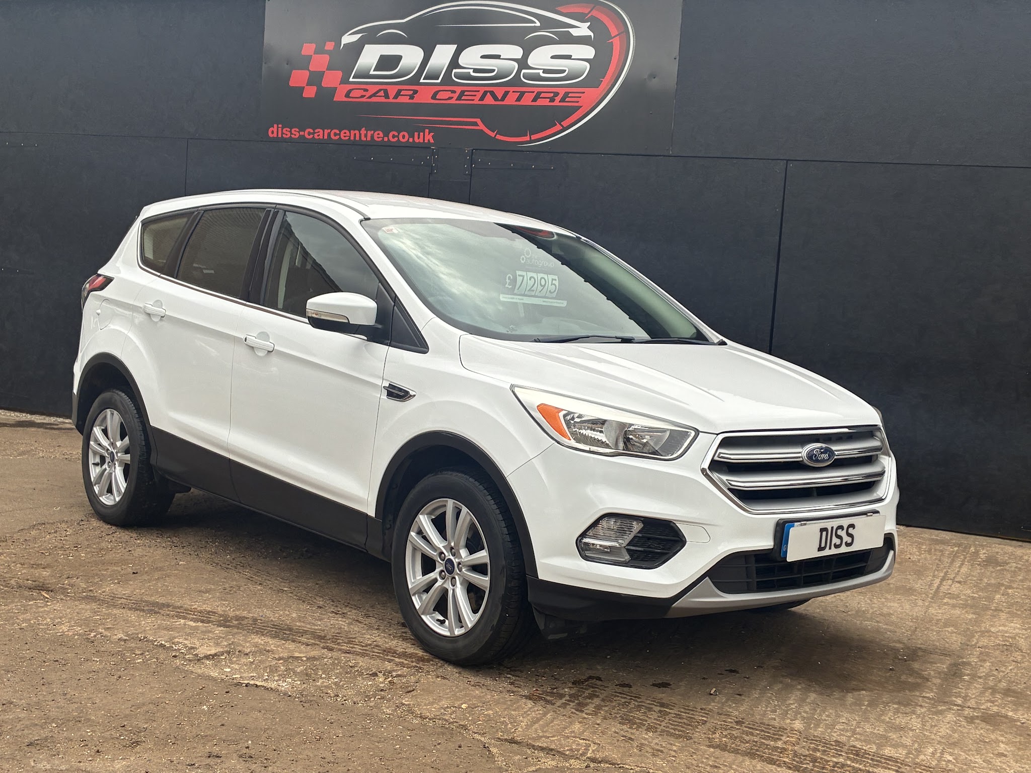 White Ford Kuga with a DISS plate surround in front of the Diss Car Centre sign
