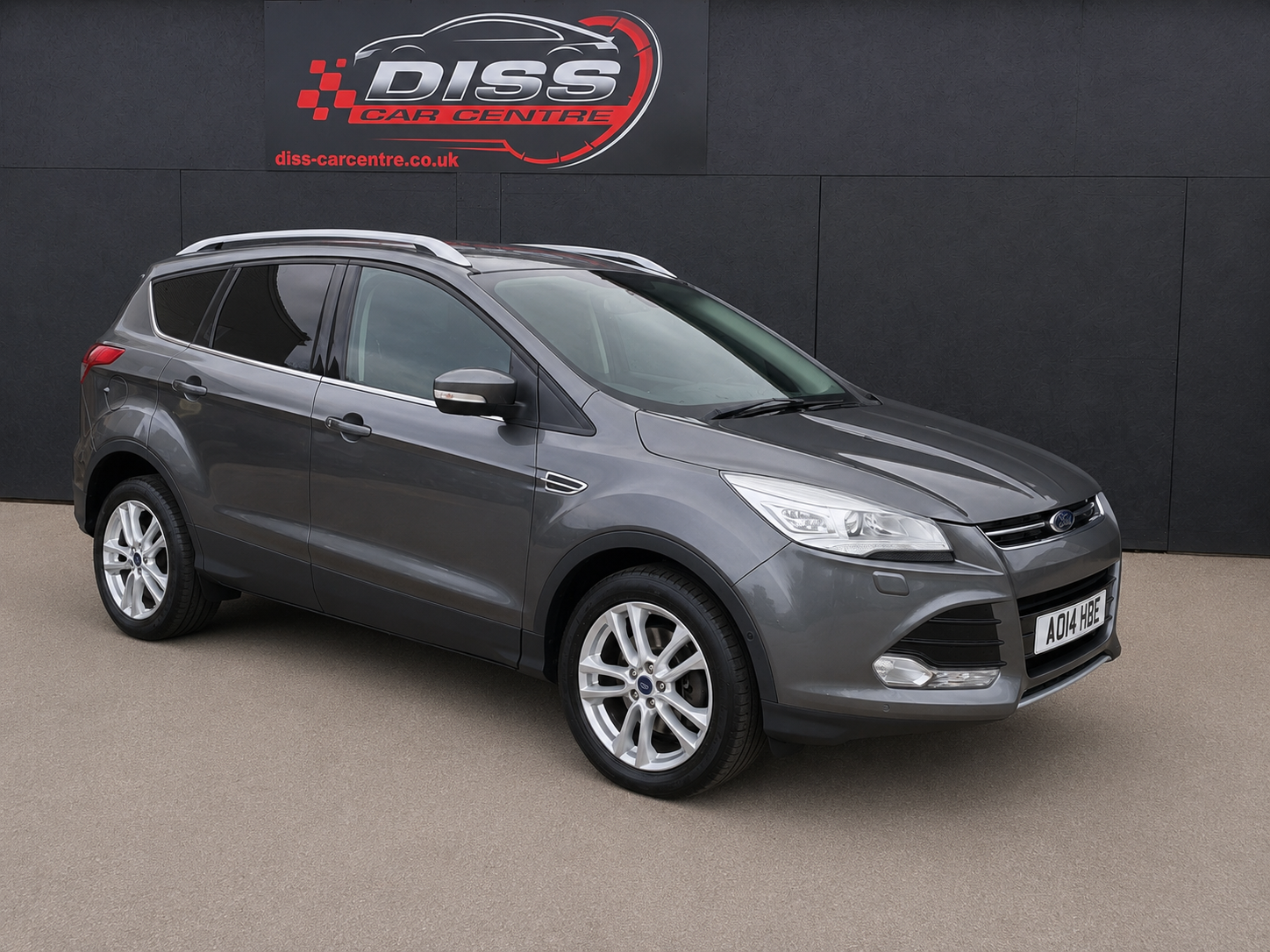 Grey Ford Kuga parked in front of the black clad Diss Car Centre building