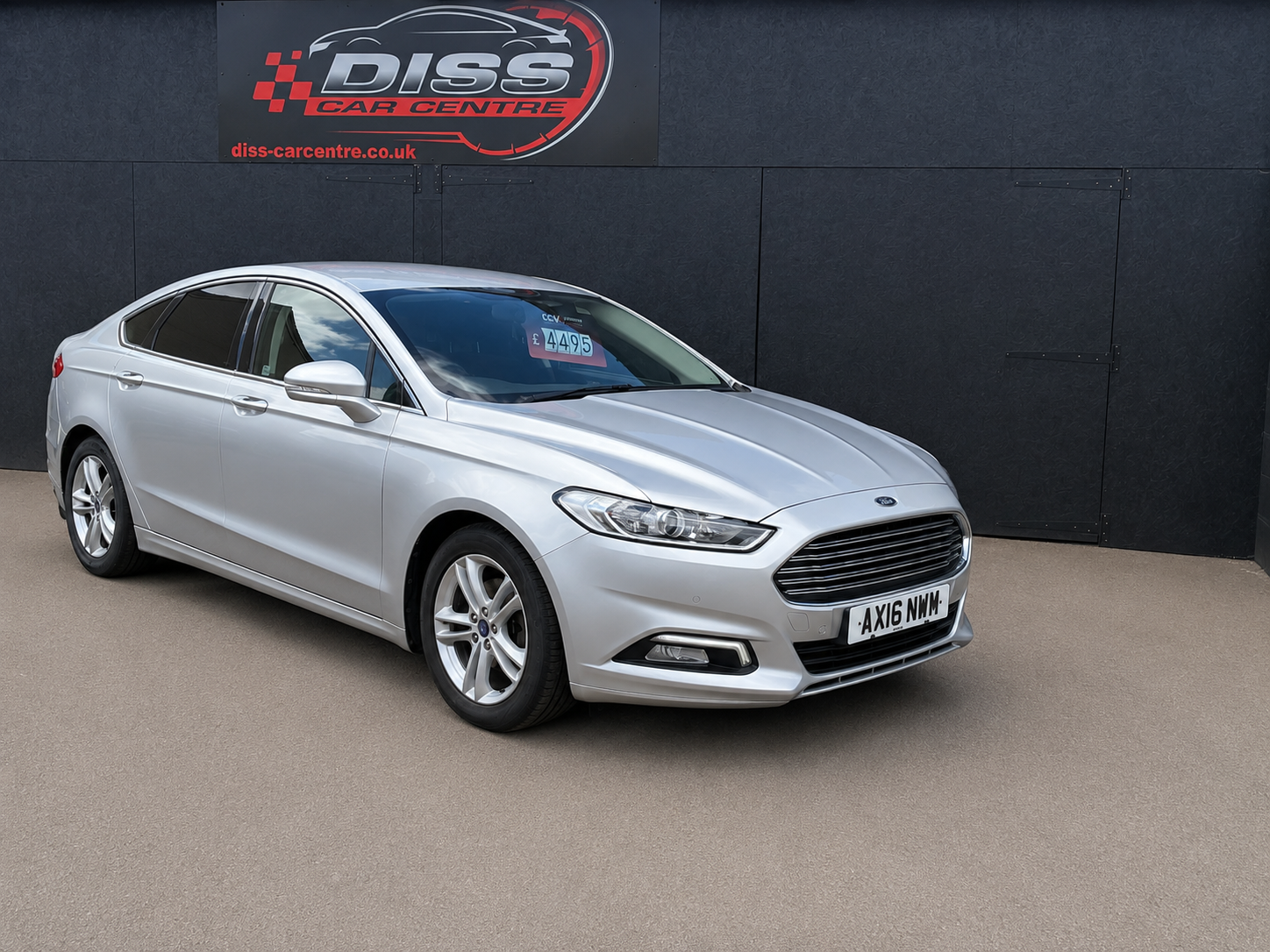 Silver Ford Mondeo saloon in front of the Diss Car Centre sign